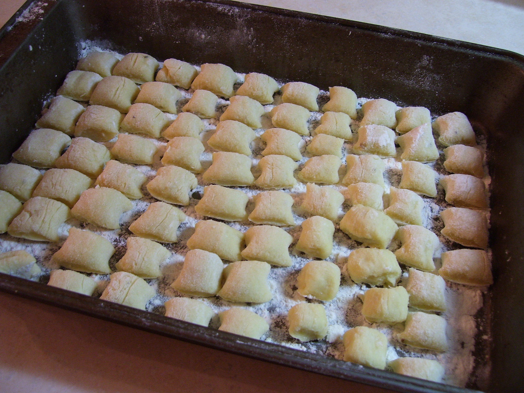 A tray of uncooked, floured gnocchi.