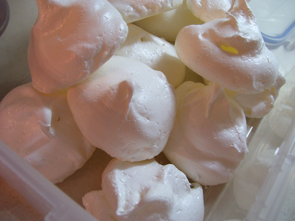 Puffed white meringues piled in a clear tub.